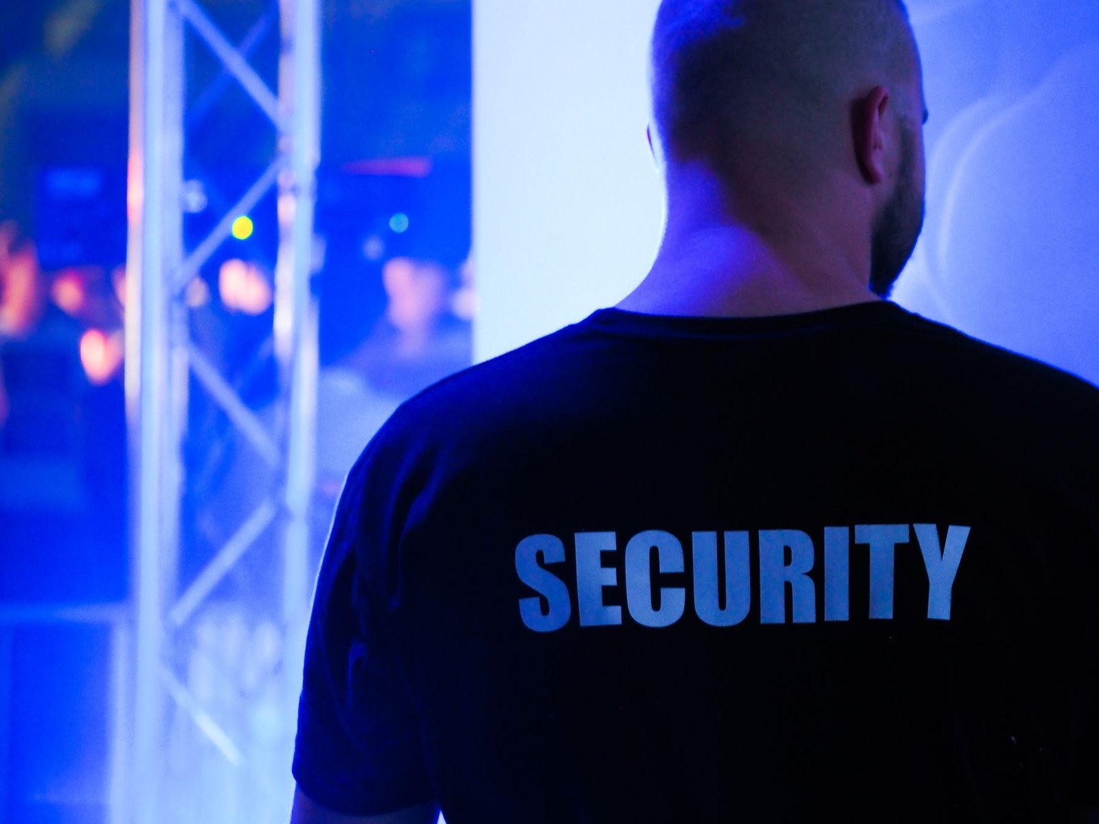 Sicherheitskraft von hinten mit SECURITY-Aufschrift auf der Uniform
